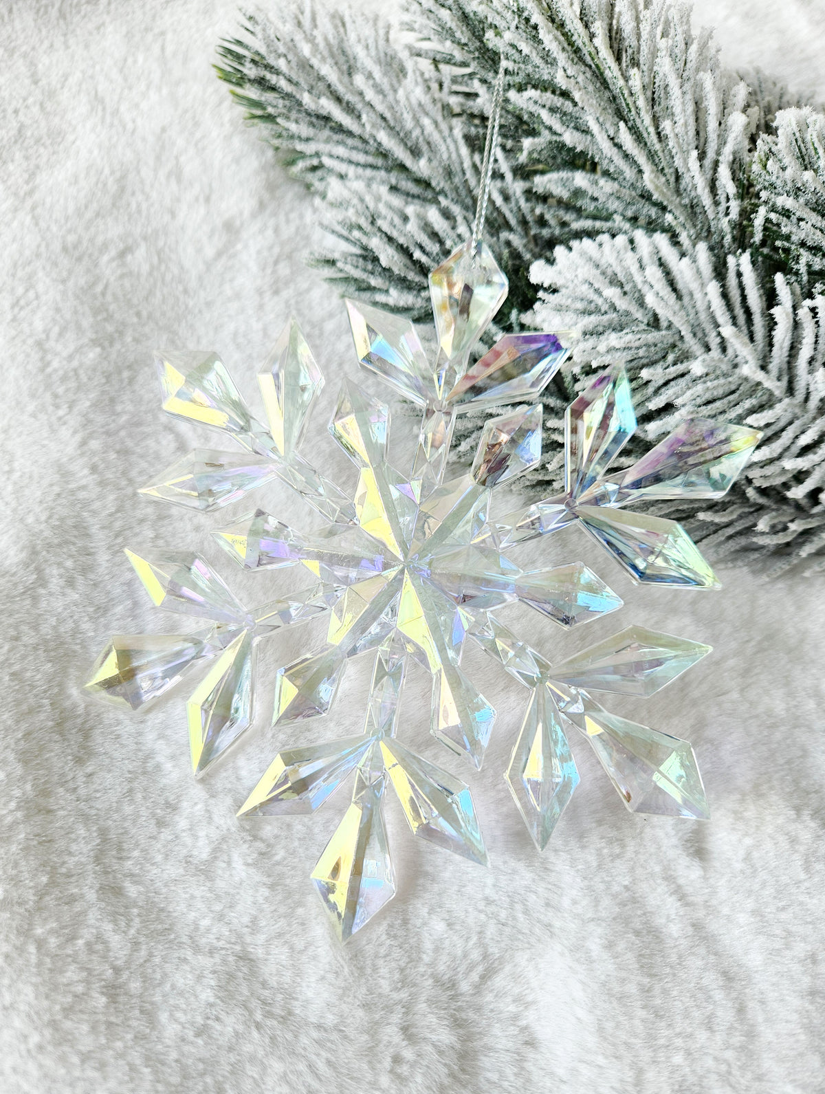 Clear faceted acrylic snowflake ornament with an iridescent rainbow shimmer