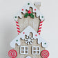Close-up of the gingerbread townhouse with snowy roof, holly, snowflake and candy cane details