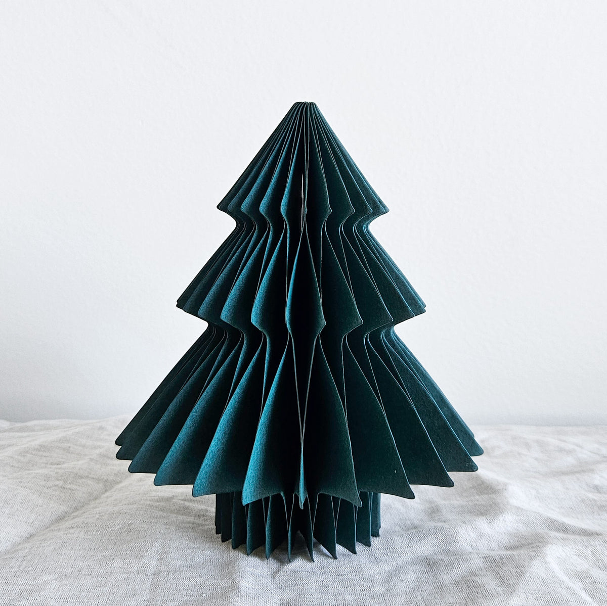 Deep green paper tabletop Christmas tree with a layered folded shape