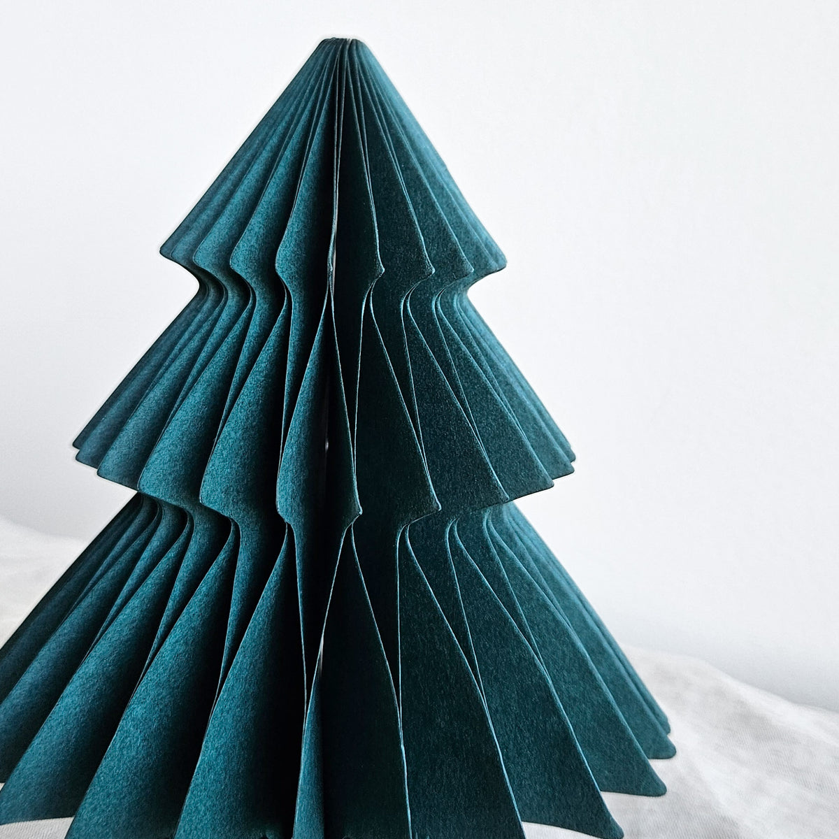 Close-up of the deep green folded paper tabletop Christmas tree