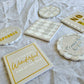 Angled view of the six Merry Sparkle ceramic coasters with festive lettering and metallic details
