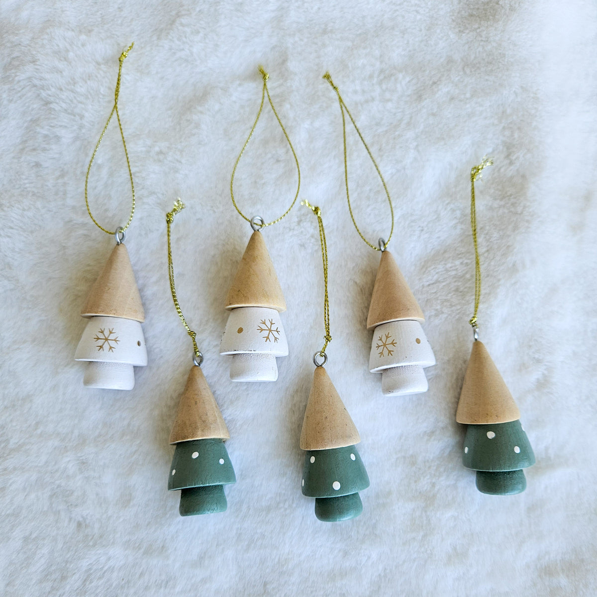 Six hanging Christmas tree ornaments, three green and three white, with natural-toned tops and gold hanging cords